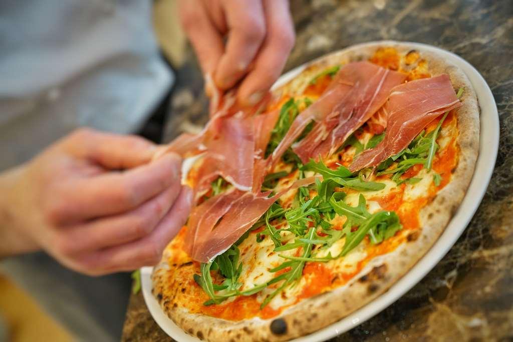 Vila Vita Rosenpark Marburg Екстер'єр фото Pizza being topped with prosciutto